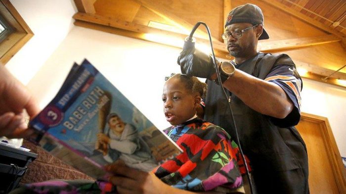 No salão desse barbeiro, as crianças que leem livros para ele ganham corte de cabelo grátis