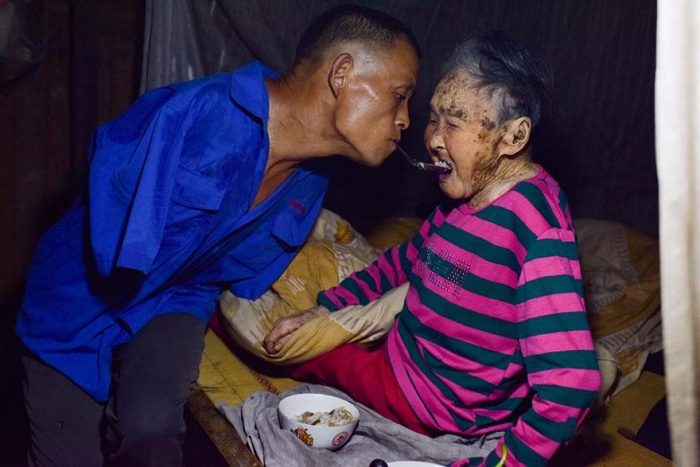 Filho sem os braços alimenta a mãe paralisada de 91 anos usando os dentes