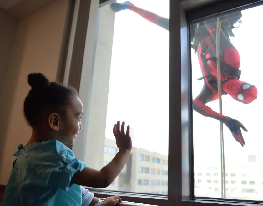 Funcionários limpam janelas fantasiados para animar crianças em hospital